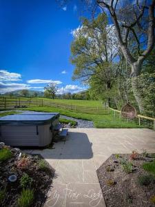 a hot tub sitting on a patio next to a field at The Prancing Pony in Llanrhaeadr-ym-Mochnant