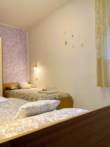una camera con due letti e uccelli sul muro di Appartamento Verdebleu - Lago e Terme a Levico Terme