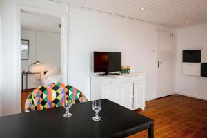 a dining room with a table and a television at Greenhouse Apartments in Helgoland