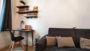 een woonkamer met een bank en een tafel bij Le Moulin Dort Hyper Centre Gare Disney in Meaux