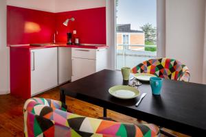 a kitchen with a black table and chairs and a sink at Greenhouse Apartments in Helgoland