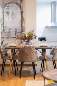 uma mesa de jantar com cadeiras e um vaso com flores em Writer's Home by Cadiz Time em Cádiz