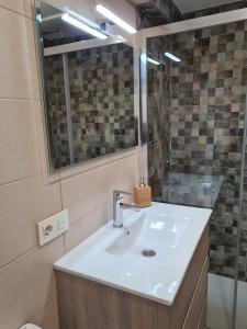 La salle de bains est pourvue d'un lavabo et d'un miroir. dans l'établissement 124A Apartamento moderno 3 habitaciones, à Gijón