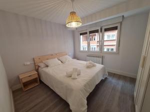 een slaapkamer met een bed met twee handdoeken erop bij 124A Apartamento moderno 3 habitaciones in Gijón