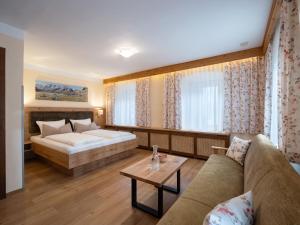 uma sala de estar com uma cama e um sofá em Gästehaus Knunbauer em Mayrhofen