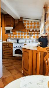 cocina con armarios de madera y horno de fogón blanco en Casita en la Sierra en Tragacete