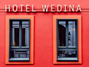 two windows on the side of a red building at Wedina Budget in Hamburg