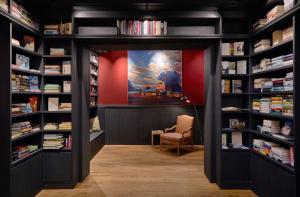 ein Zimmer mit Bücherregalen und einem Stuhl in einer Bibliothek in der Unterkunft Wedina Budget in Hamburg