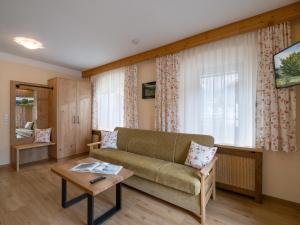 uma sala de estar com um sofá e uma mesa em Gästehaus Knunbauer em Mayrhofen