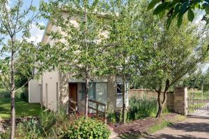 een huis met bomen ervoor bij Lakeside property with spa access on a nature reserve Reid Villa CW01 in Somerford Keynes