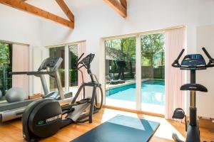 een fitnessruimte met een fitnessruimte met een zwembad bij Lakeside property with spa access on a nature reserve Reid Villa CW01 in Somerford Keynes