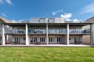 Somerford KeynesにあるLuxury apartment with spa access on a nature reserve Goldeneye HM107のテーブルと椅子が備わる建物の外観