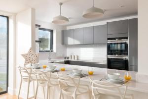 a kitchen with a table and chairs in a kitchen at Luxury property with access into Spa on a nature reserve Beaumont Village 14 in Warmwell +8 photos