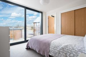 a bedroom with a bed and a large window at Luxury property with access into Spa on a nature reserve Beaumont Village 14 in Warmwell