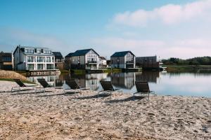 a group of chairs sitting on the beach next to the water at Luxury property with access into Spa on a nature reserve Beaumont Village 14 in Warmwell