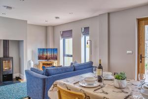 een woonkamer met een blauwe bank en een tafel bij Luxury property with access into Spa on a nature reserve Beaumont Village 5 BV05 in Warmwell