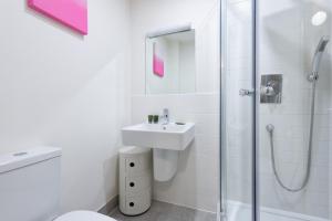 Somerford KeynesにあるLakeside property with spa access on a nature reserve Pochard HM109の洗面台とシャワー付きの白いバスルーム +6枚の写真
