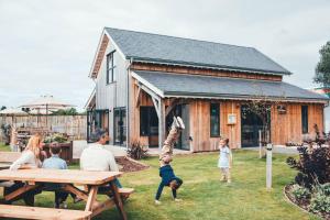 Somerford KeynesにあるLakeside property with spa access on a nature reserve Pochard HM109の家の前のピクニックテーブルに座る人々