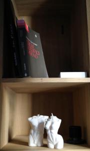 un par de botas blancas en un estante con libros en The colors house, en Bari