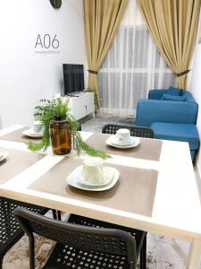 a dining room table with two cups and plates on it at SUWAN Guesthouse A06 - 2BR Apartment with Pool Near UKM in Kajang