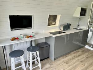a kitchen with a counter with two stools and a sink at Y Dderwen in Oswestry