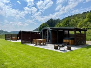 a pavilion with a table and chairs in the grass at Y Dderwen in Oswestry