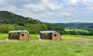 two hobbit houses in a field of grass at Y Dderwen in Oswestry +4 photos