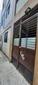 a building with a garage door with graffiti on it at The Pine Place - Baguio in Baguio