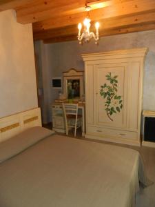 una camera con letto, scrivania e lampadario pendente di Affittacamere Ai Fiori a Cittadella