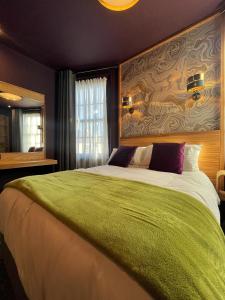 a bedroom with a large bed with a green blanket at Lough Rooms at The Artisan in Strangford
