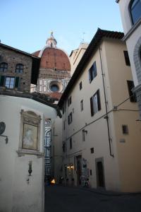 une allée entre deux bâtiments avec une tour dans l'établissement Adelaide House, à Florence