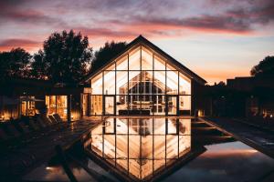 a greenhouse with a sunset in the background at Lakeside property with spa access on a nature reserve Keel House CW23 in Somerford Keynes