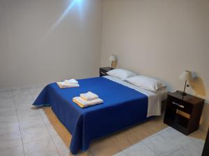 Un dormitorio con una cama azul con toallas. en La Candida en Tunuyán