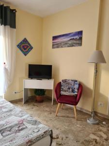 um quarto com uma secretária, uma cadeira e uma televisão em Casa dell amore 2 em Sanremo