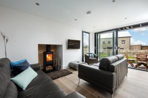 a living room with a couch and a fireplace at Lakeside property with access into Spa on a nature reserve All Decked Out BV28 in Warmwell