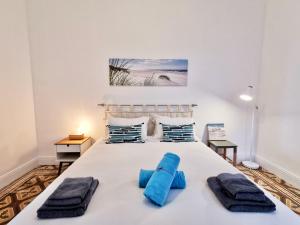 a bedroom with a large white bed with blue pillows at Le FOCH2 by Booking Guys in Villefranche-sur-Mer