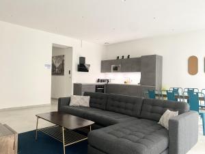 ein Wohnzimmer mit einem Sofa und einem Tisch sowie eine Küche in der Unterkunft Appartement Urban 5 in Nizza