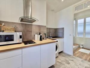 a kitchen with white cabinets and a microwave at LE FOCH by Booking Guys in Villefranche-sur-Mer +9 photos