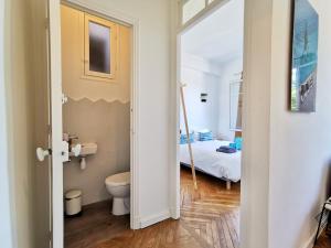 a bathroom with a toilet and a bed in a room at LE FOCH by Booking Guys in Villefranche-sur-Mer