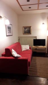 a living room with a red couch and a television at Casavacanze Abetone in Abetone