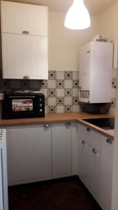 a kitchen with white cabinets and a microwave on a counter at Casavacanze Abetone in Abetone