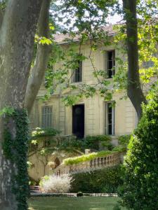 an old stone house with a door and trees at La Suite de la Bastide in Val-de-Dagne