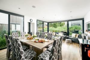 uma sala de jantar com mesa e cadeiras em Lakeside roof terrace with Spa access Le Mirage em Somerford Keynes