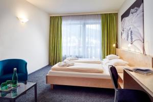 ein Hotelzimmer mit einem Bett und einem Fenster in der Unterkunft Loisach Smarthotel by keyone in Lermoos