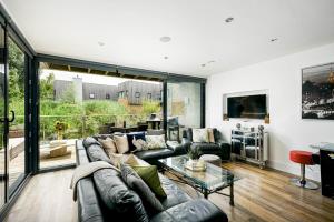 uma sala de estar com um sofá e uma mesa em Lakeside roof terrace with Spa access Le Mirage em Somerford Keynes