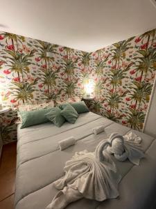 a bedroom with a large bed with palm wallpaper at Guarracino P. Capodimonte Suite in Naples