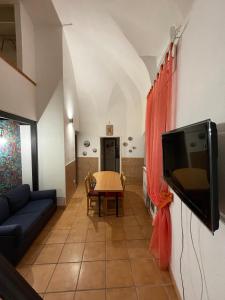 - un salon avec une télévision et une table dans l'établissement Guarracino P. Capodimonte Suite, à Naples