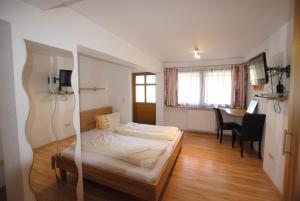 a bedroom with a bed and a dining room at Hotel Gasthof Seeblick in Zeutschach