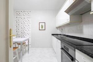 a white kitchen with a sink and a table at Paraguay 14 in Vigo +31 photos