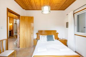 a bedroom with a large bed with a wooden headboard at House Eufrosyne in Moutoullas